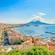 The harbor of Naples with moored boats surrounded by a hilly landscape filled with buildings
